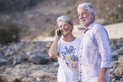 Smiling mature couple standing at beach