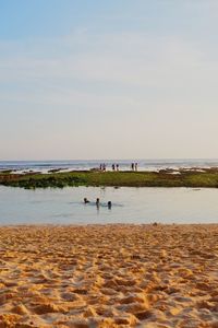 People on beach against sky