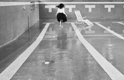 Running girl in empty swimming pool