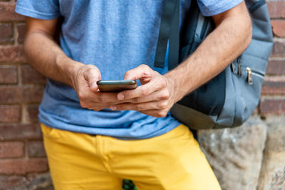 Midsection of man using mobile phone