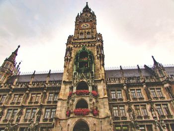 Low angle view of clock tower against cloudy sky