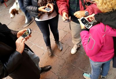 High angle view of friends using smart phones