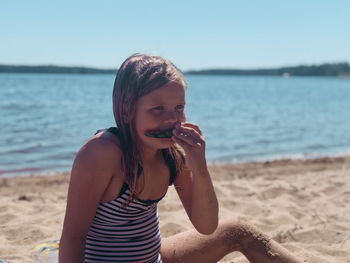 Happy girl on beach against sea