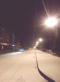 Snow covered road against sky at night