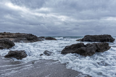 Rocks in sea against sky