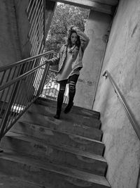 Full length portrait of woman standing on staircase