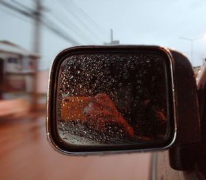 Close-up of wet side-view mirror