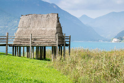 Built structure on field by mountains against sky