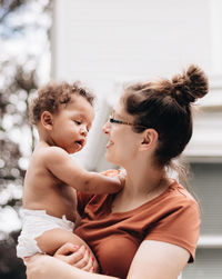 Mother embracing son sitting at home