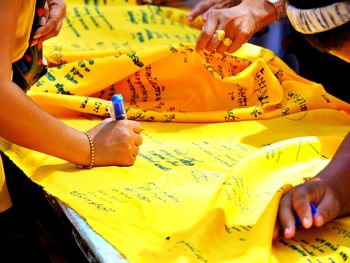 Midsection of woman holding yellow dress