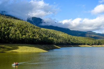 Scenic view of lake by mountains against sky