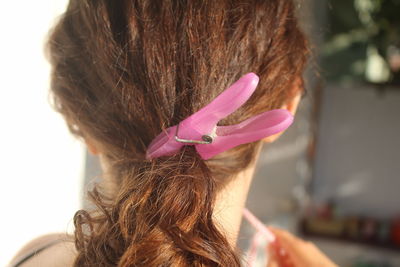 Rear view of woman hair tied with clothespin at home