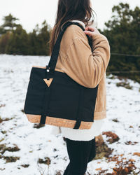 Rear view of woman standing on snow field