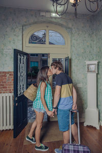 Couple kissing at entrance of hotel