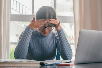 Young woman using laptop at home