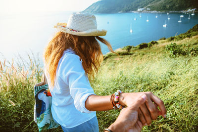 Midsection of woman wearing hat on field