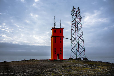 Lighthouse by sea against sky