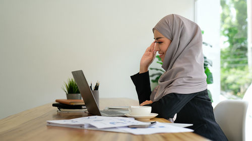 Young woman using laptop on table