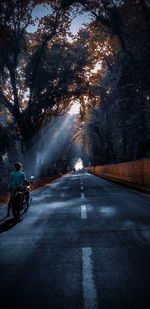 Rear view of man walking on road in city