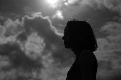 Side view of silhouette woman standing against sky