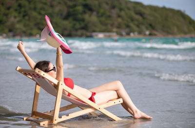 Woman sitting on chair at beach