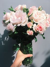 Close-up of hand holding rose bouquet