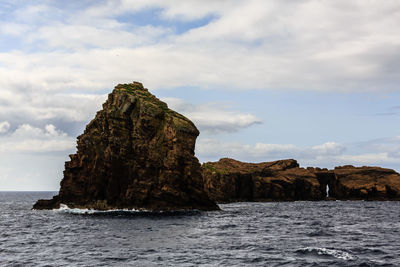 Rock formations by sea against sky