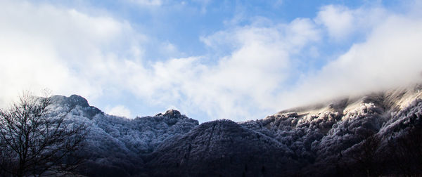 Low angle view of snowcapped mountains against sky