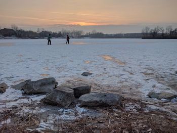 Scenic view of frozen beach against sky during sunset