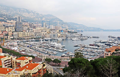 High angle view of city by sea against sky