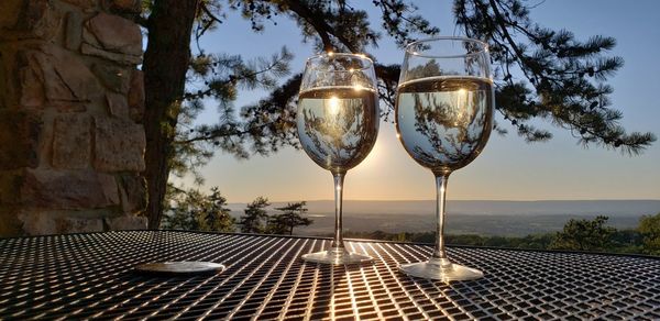 Glass of wine on table against sky