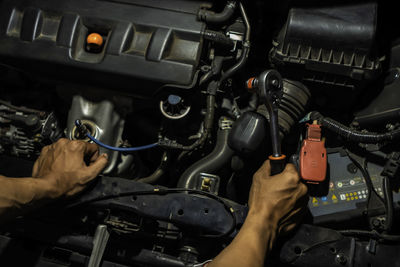 High angle view of man repairing car in garage