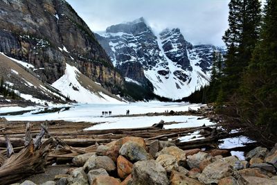 Scenic view of stream by snowcapped mountains during winter