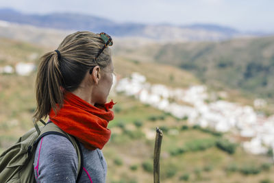 Young woman looking at mountain against sky