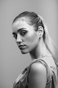 Side view portrait of young woman against white background