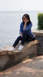Young woman sitting on pier