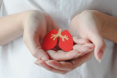 Midsection of woman holding heart shape