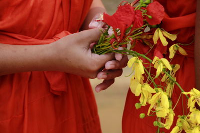 Cropped image of woman holding red rose flower