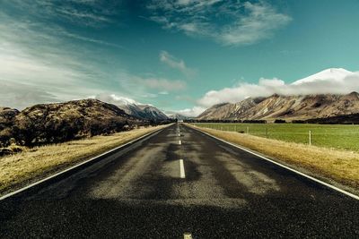 Empty road with mountains in background