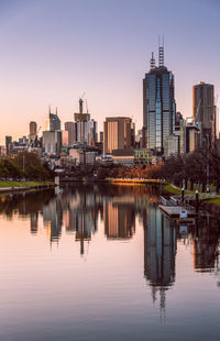 Reflection of buildings in city at sunset