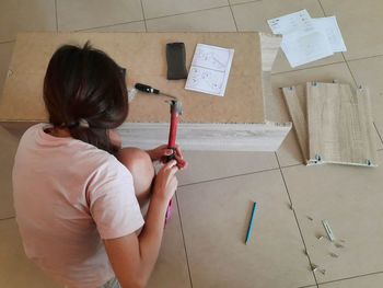 Young girl assembling furniture