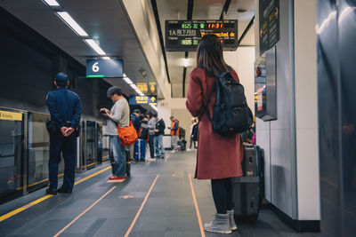 Woman with luggage standing at airport terminal