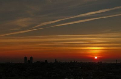 Silhouette cityscape against sky during sunset