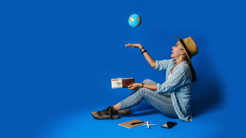Digital composite image of young woman against blue ball