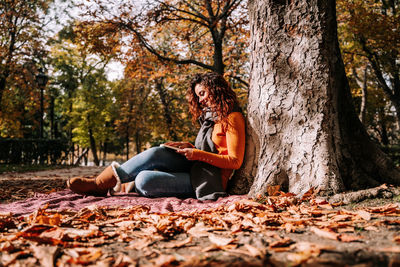 Woman sitting in park during autumn