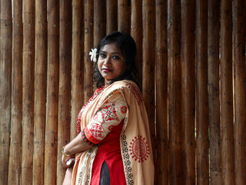 Portrait of smiling woman standing against wall