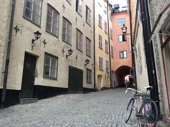 Bicycle parked on street amidst buildings