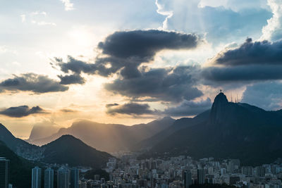 Town by mountains against sky during sunset