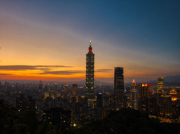 Illuminated cityscape against sky at night