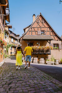 Rear view of people walking on street against buildings